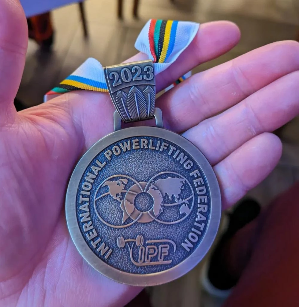 The IPF World Championships 2023 bronze medal in Andrew's hand